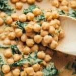 A skillet of creamy Marry Me Chickpeas with sun-dried tomatoes and basil.