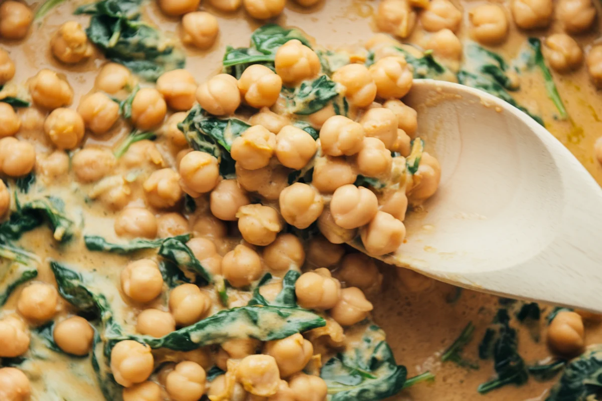 A skillet of creamy Marry Me Chickpeas with sun-dried tomatoes and basil.